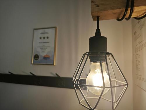 aendant light hanging from a wall in a room at Valley Vendégház in Eger