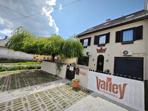 a house with a sign that readsvalleyyards at Valley Vendégház in Eger