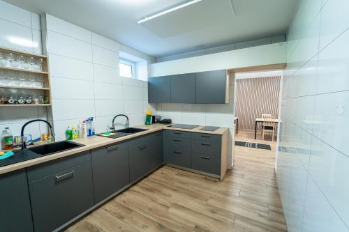 a kitchen with gray cabinets and a wooden floor at Chata Markétka in Dobré