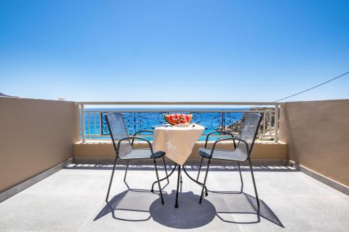 a balcony with two chairs and a table on a roof at Apolis Beachscape Hotel in Amoopi
