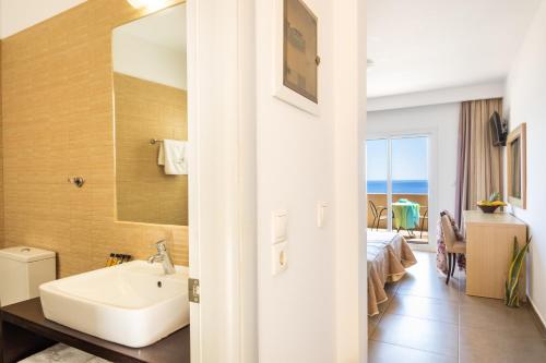 a bathroom with a sink and a view of the ocean at Apolis Beachscape Hotel in Amoopi