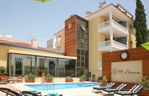 a hotel with a swimming pool in front of a building at St Elena Boutique Residence in Larnaka