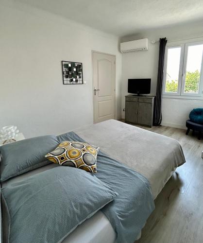 une chambre avec un grand lit et une télévision dans l'établissement Magnifique appartement devant la plage, à Propriano