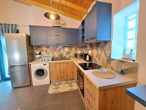 a kitchen with a refrigerator and a washing machine at A GEORGE Luxury house in Artemida