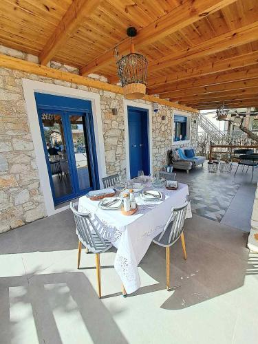 a white table and chairs on a patio at A GEORGE Luxury house in Artemida