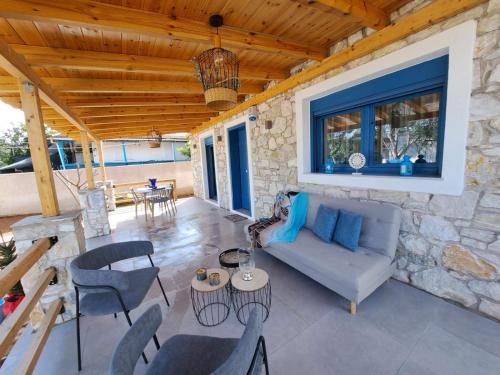 a patio with a couch and chairs and a table at A GEORGE Luxury house in Artemida