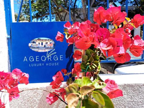 a blue sign with red flowers in front of a house at A GEORGE Luxury house in Artemida