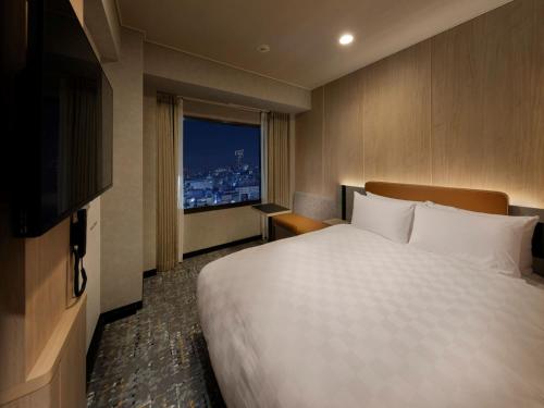 a hotel room with a large bed and a window at Shinjuku Prince Hotel in Tokyo