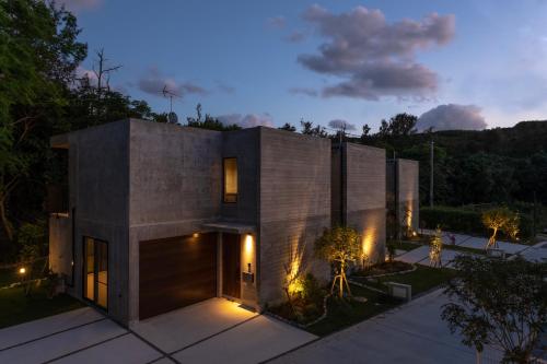 a concrete house with lights on it at night at RYUKYU BREEZE 1棟貸し 天然ビーチまで徒歩30秒 プライベートプール付きVilla 北部 in Nago