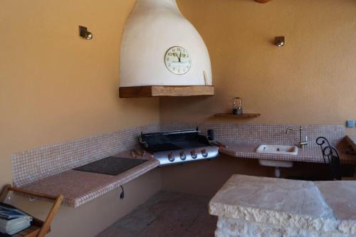 une cuisine avec un évier et une horloge murale dans l'établissement Avignon grande villa avec piscine sans vis à vis, à Avignon