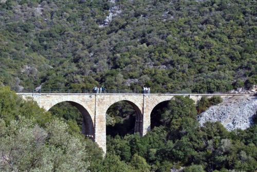 a bridge on a mountain with people standing on it at Harmony Platanidia Pelion in Platanidia