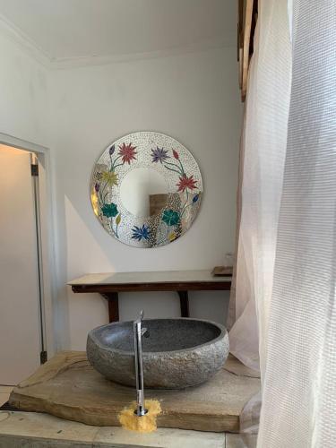 a bathroom with a stone sink and a mirror at Lavender star house in Kuta