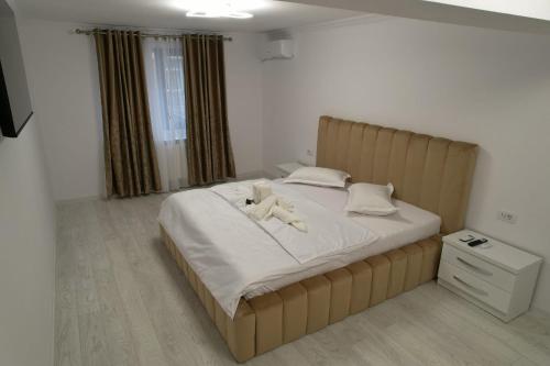 Un dormitorio con una cama con un osito de peluche encima. en Apartament Cosmi Ari, en Băile Herculane