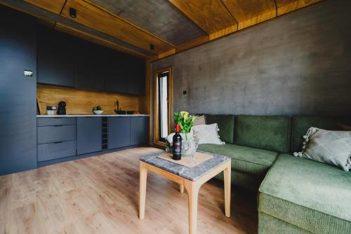 a living room with a green couch and a table at Osada Marchowo in Kielno