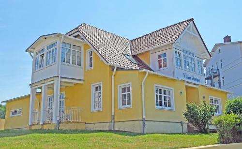 a yellow house with a gray roof at ruhig gelegenes Appartementhaus mit Ferienwohnungen VSo in Göhren