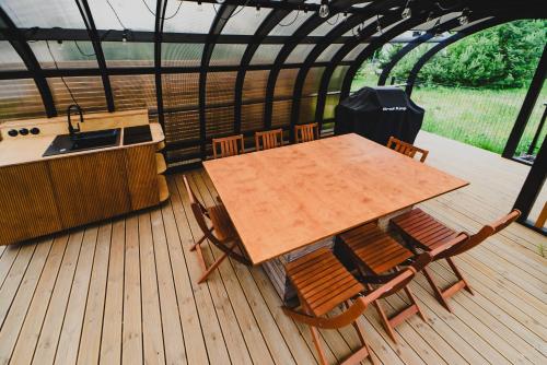 a wooden table and chairs on a wooden deck at Osada Marchowo in Kielno