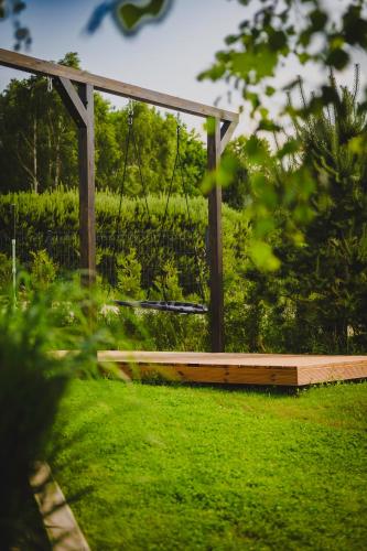 a swing in a garden with green grass at Osada Marchowo in Kielno