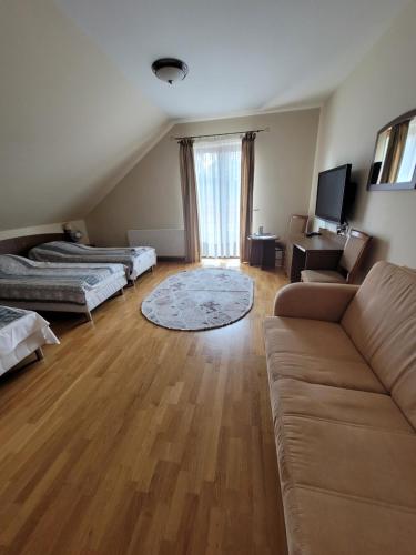 salon z dwoma łóżkami i kanapą w obiekcie Dworek Biesiadny w mieście Radzewice