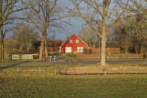 a red house in the middle of a street at Gastenverblijf Op zijn Zweeds in Echten
