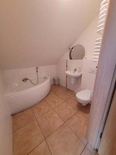 une salle de bains avec baignoire, toilettes et lavabo dans l'établissement Dworek Biesiadny, à Radzewice
