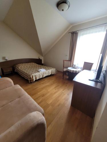 un soggiorno con un letto e un divano di Dworek Biesiadny a Radzewice