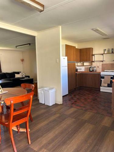 a living room with a table and a kitchen at Brock Ag Vineyard Stay in Waikerie