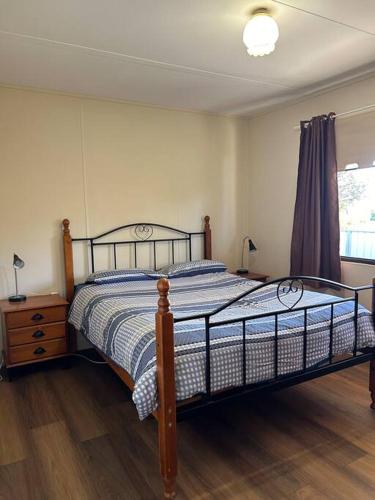 a bedroom with a bed and a wooden floor at Brock Ag Vineyard Stay in Waikerie