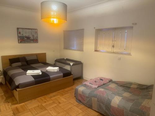 a bedroom with two beds and a window and a lamp at SEA Villa Rosa Seaside & Garden. in Porto