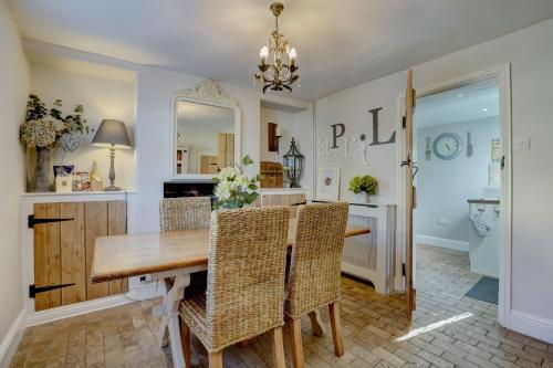 une salle à manger avec une table et des chaises en bois dans l'établissement April Cottage by Winterton Cottages, à Winterton-on-Sea