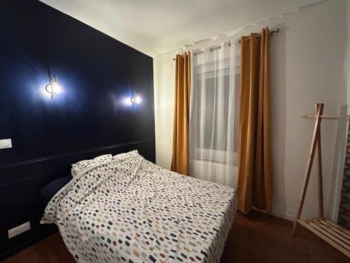 a bedroom with a bed and two lights on the wall at Appart 4 personnes Bethune Centre in Béthune