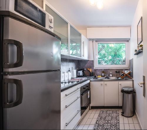 une cuisine avec un réfrigérateur en acier inoxydable dans l'établissement Le Havre de paix à Suresnes, à Suresnes