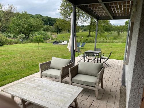 a patio with two chairs and a table and an umbrella at Scheier (Ferienwohnungen) in Perl