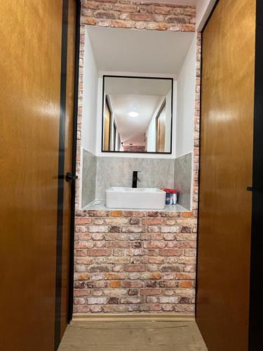 a bathroom with a sink and a brick wall at Alojamiento a 1 min de la Plaza de Toros Pachuca in Pachuca de Soto