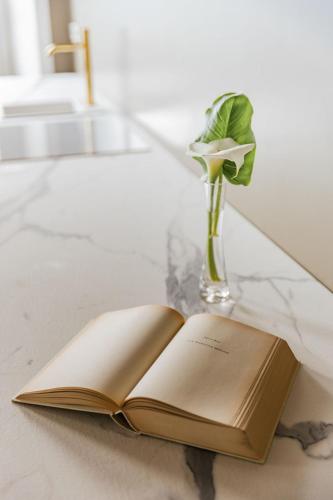 an open book on a table with a vase of flowers at Villa Antica Colonia SPA & Wellness in Pettenasco