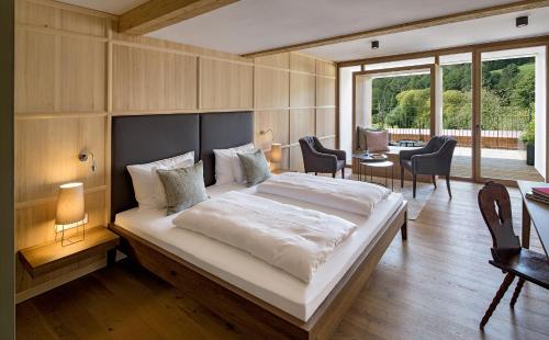 a bedroom with a large bed and a table and chairs at Gutshofhotel Winkler Bräu in Lengenfeld