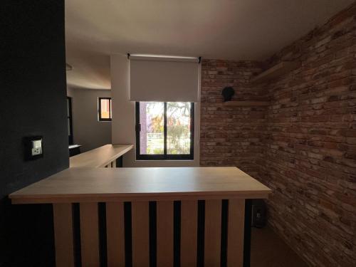 a kitchen with a table and a brick wall at Alojamiento a 1 min de la Plaza de Toros Pachuca in Pachuca de Soto
