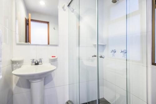 a bathroom with a shower, sink, and mirror at Hotel Portofino in Bogotá