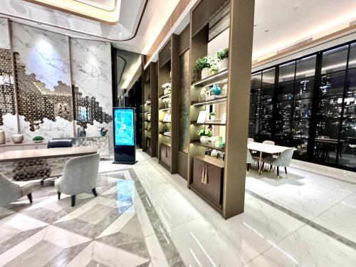 a lobby with a table and chairs in a building at Benson Tower Surabaya Apartment 2BR by Le Ciel Hospitality in Lontar