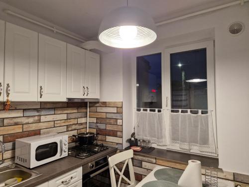 a kitchen with white cabinets and a microwave at Central Mangalia in Mangalia