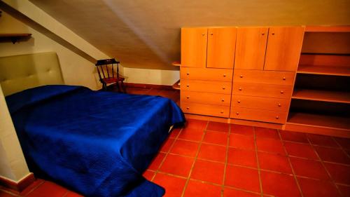 a bedroom with a blue bed and a wooden cabinet at Aloha Village - Bed&Pet in Messina