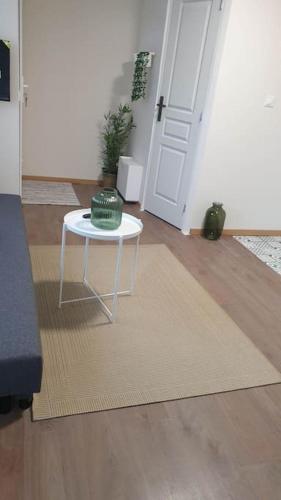 - une table blanche dans une chambre avec porte dans l'établissement le Jasmin, à Martigues