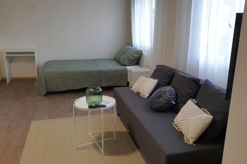 un salon avec un canapé et un lit dans l'établissement le Jasmin, à Martigues