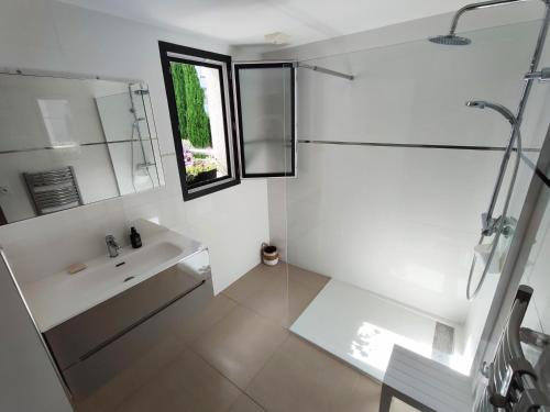 une salle de bain blanche avec un lavabo et une fenêtre dans l'établissement ARCA C14, à Porto-Vecchio