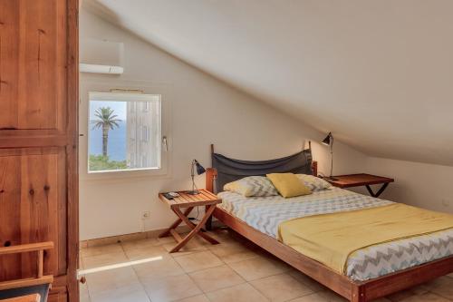 - une chambre avec un lit et une fenêtre avec un palmier dans l'établissement Casa Catalina, à Toga