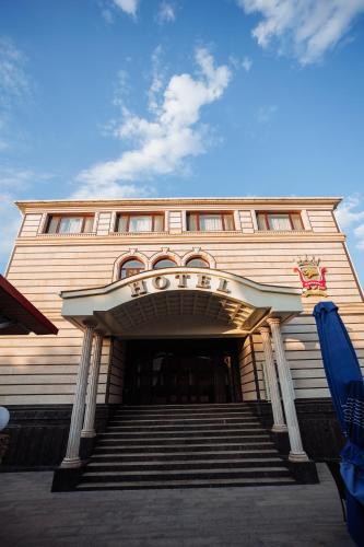 a building with stairs in front of a building at Edem Hotel Shymkent in Shymkent