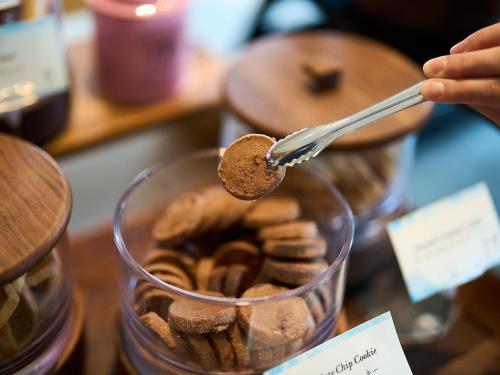 a person holding a spoon over a bowl of cookies at Cerulean Tower Tokyu Hotel, A Pan Pacific Partner Hotel in Tokyo