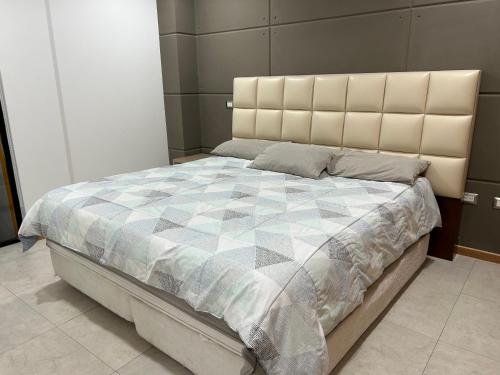 a bedroom with a large bed with a quilt on it at Departamento Ejecutivo 5 minutos de Galerías Pachuca in Pachuca de Soto