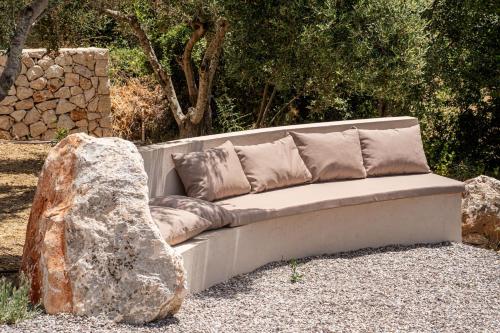 a couch sitting next to a large rock at Lithos Art Villas in Sarlata
