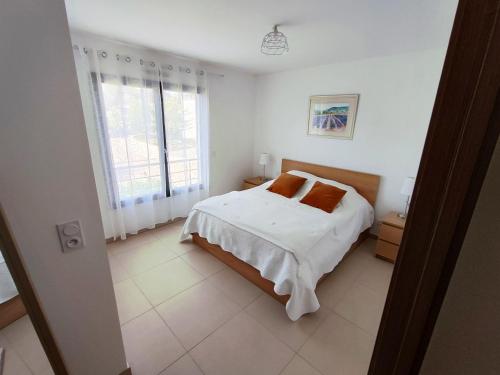 une chambre blanche avec un lit et une fenêtre dans l'établissement ARCA C14, à Porto-Vecchio