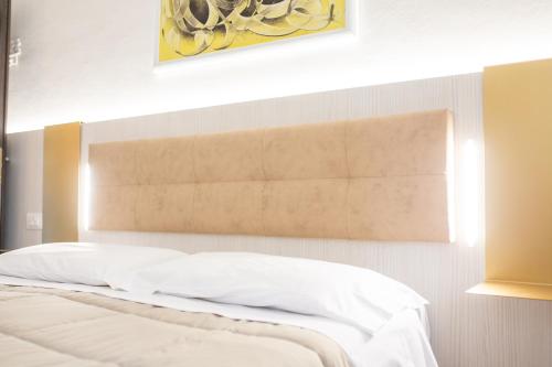 a bedroom with a bed with white sheets at Villa Liliana in Cervia